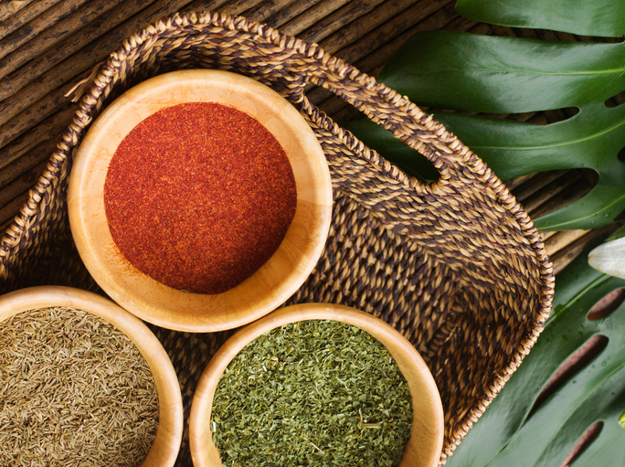 Spices in basket on table outdoors, overhead view